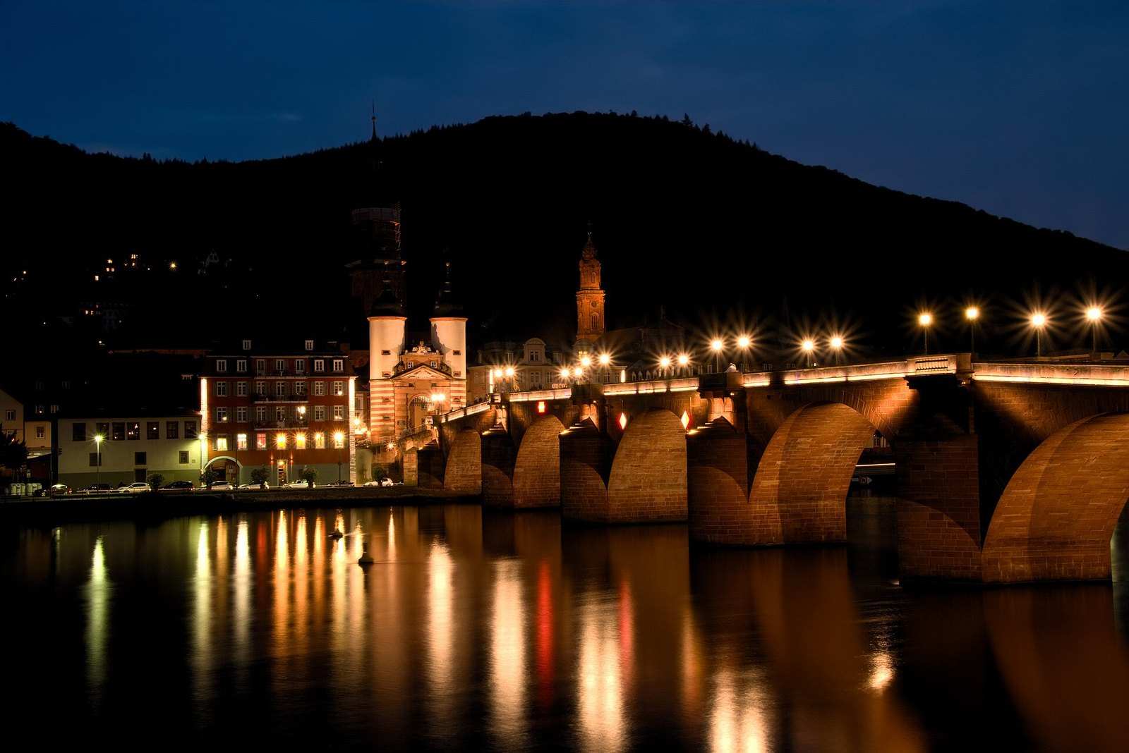 Alte Brücke und Brückentor bei Nacht mit Spiegelungen im Neckar