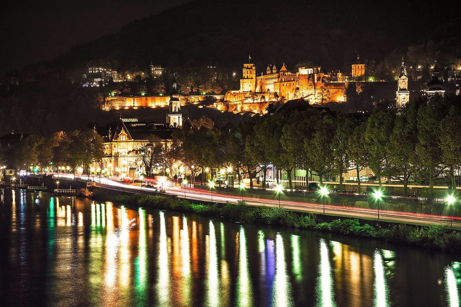 Schloss und Neckarufer bei Nacht mit Lichtspiegelungen im Fluss